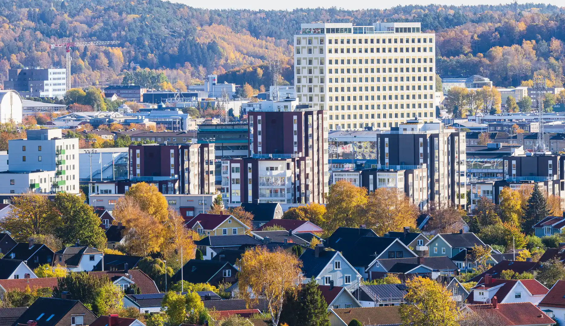 Mölndal i höstfärger med bostadshus och stadens centrum i bakgrunden